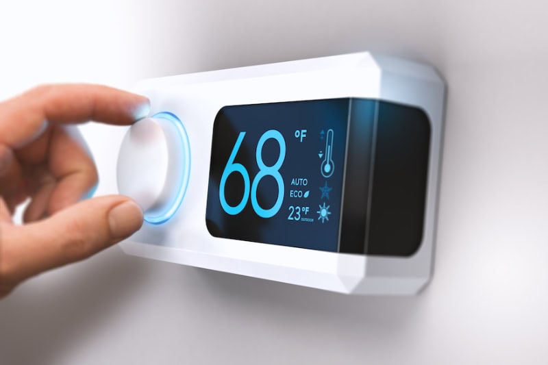 Modern digital thermostat controlling home temperature and HVAC system.